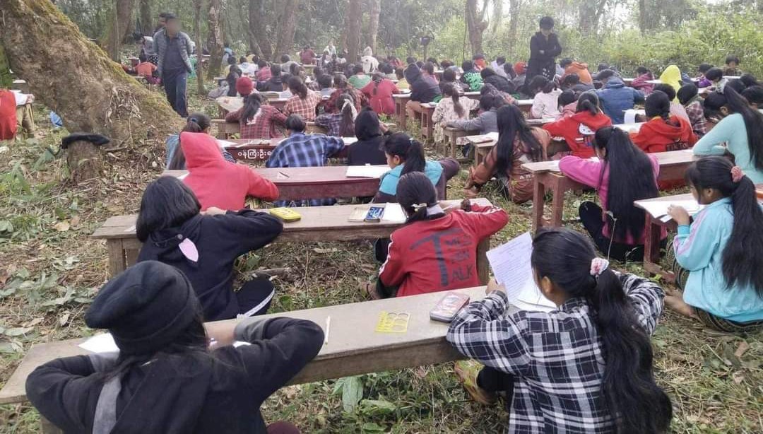 မြန်မာစစ်အစိုးရ၏ လေကြောင်းတိုက်ခိုက်မှုကို ကြောက်ရွံ့သောကြောင့် ကန်ပက်လက်မြို့နယ်ရှိ ကလေးငယ်များ တောထဲတွင် စာမေးပွဲဖြေဆိုနေကြစဉ် (Photo: The Chin Journal Twitter, March 31, 2024)
